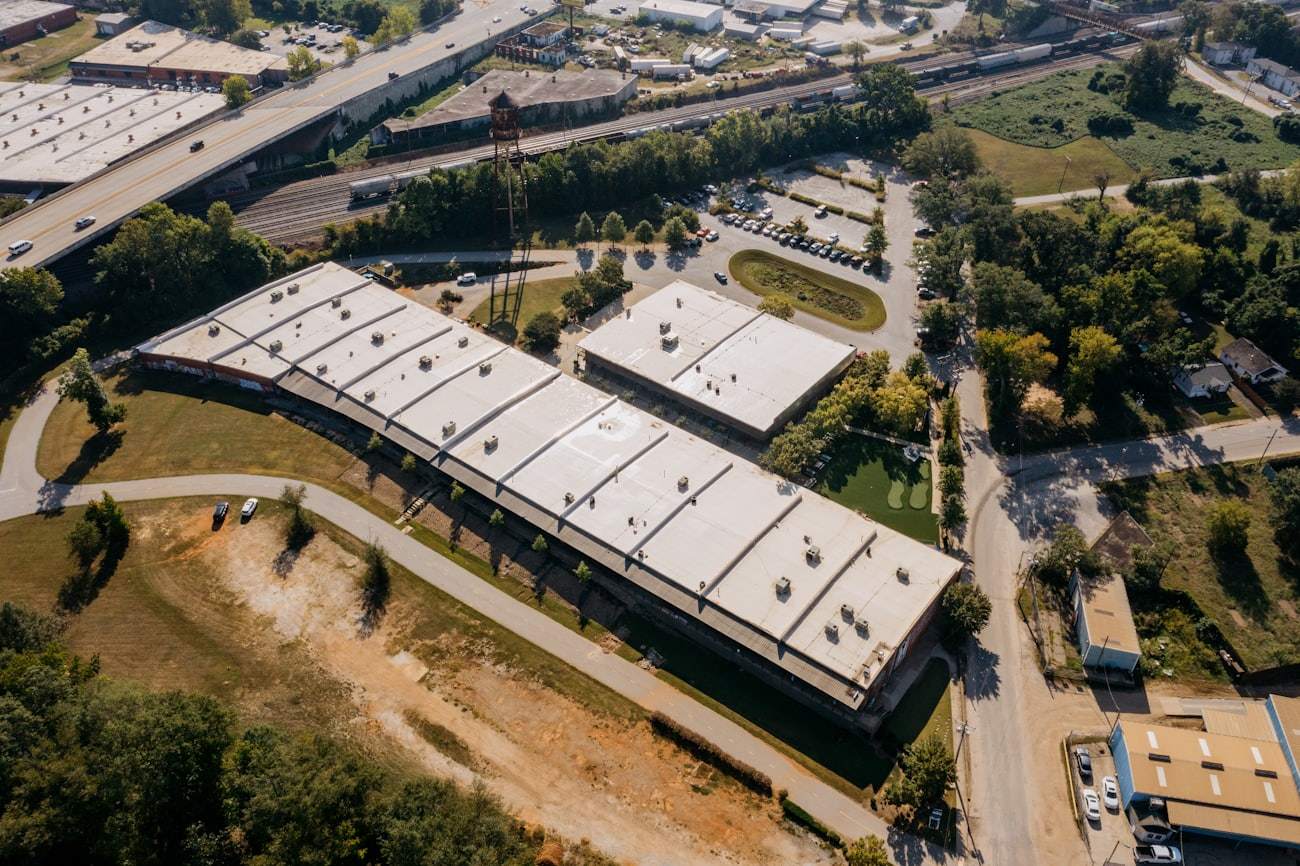 Aerial view of large commercial buildings with white flat roofs
