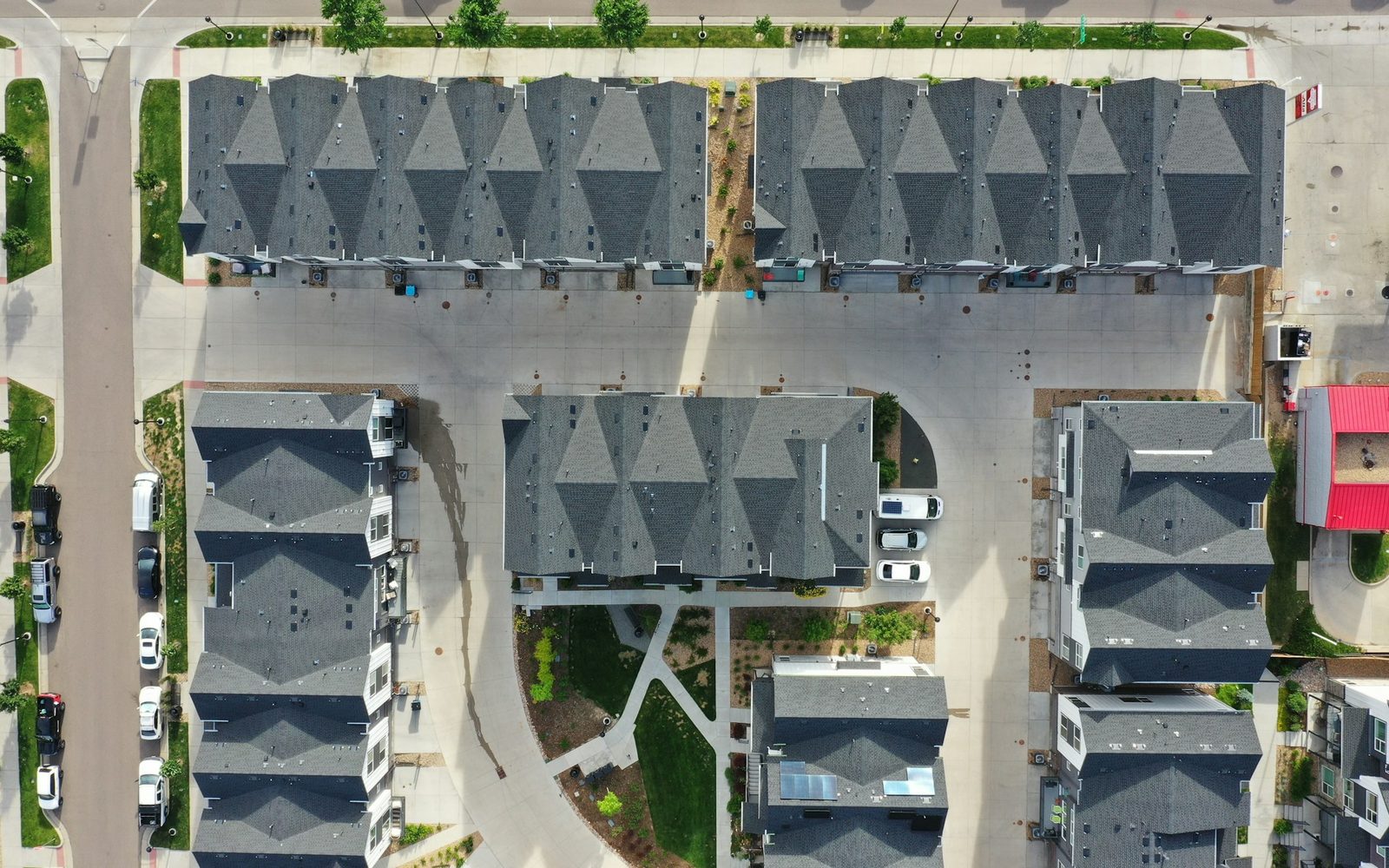 Aerial view of newly built attached homes with gray shingle roofs