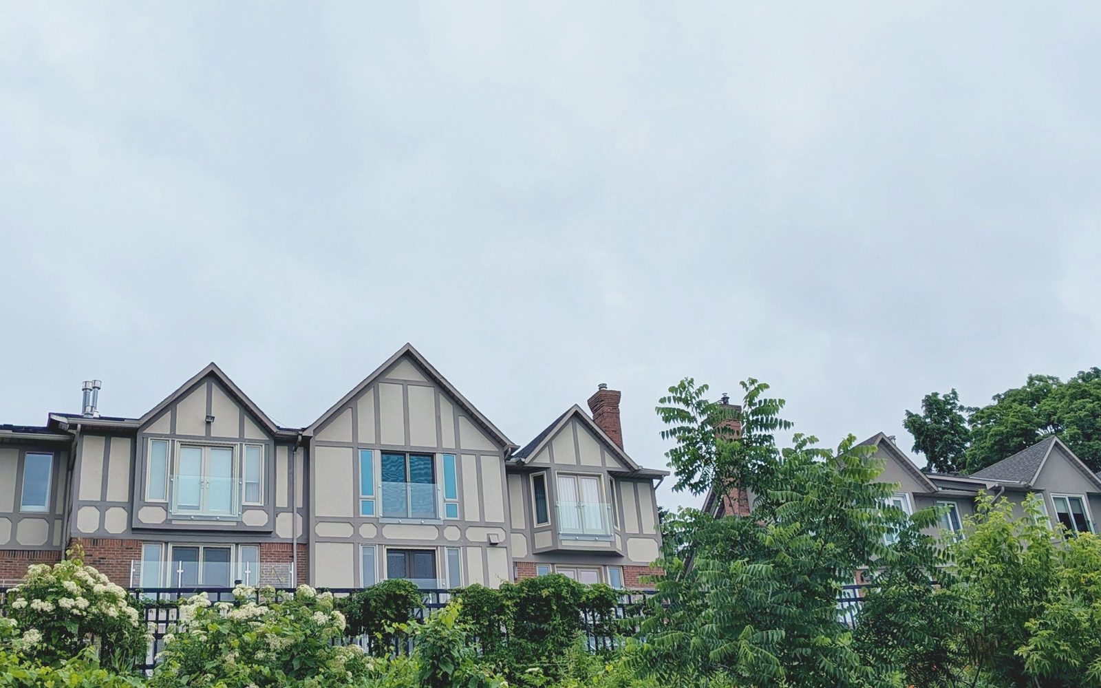 Row of attached townhomes with steep gables and asphalt shingle roofs