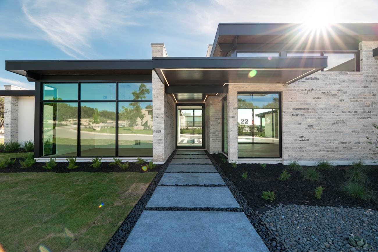 A stone home with floor-to-ceiling black-frame energy-efficient windows