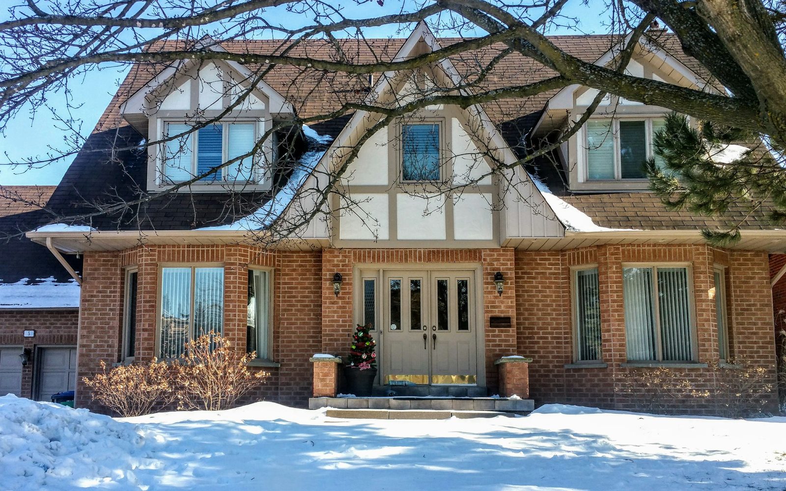 Asphalt shingle roof with dormers and an attached garage on a Wisconsin suburban home